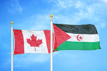 Canada and Western Sahara two flags on flagpoles and blue cloudy sky