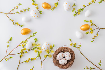 Flat lay easter composition with a willow branch and eggs on a white background