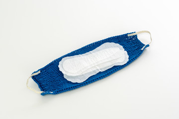 selbst gestrickter Mundschutz mit Einlage vor weißem Hintergrund