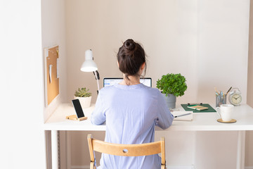 Woman using laptop, workplace in modern style. Communication and telecommuting. Social distance
