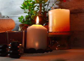 composición de spa para terapias de masajes con velas, aceites, sales minerales, flores y otros objetos decorativos 