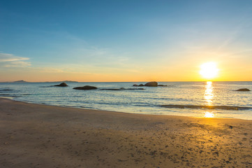 Fototapeta na wymiar Beach wave with orange sunrise background