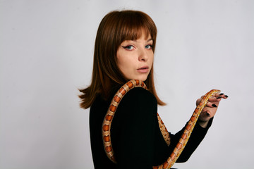 Beautiful woman in black bodywear and snake. Ginger model girl with fashion perfect make up.