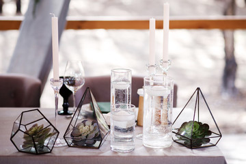 Festive wedding table setting with flowers, napkins, cutlery, glasses and candles, bright summer table decor. Wedding decor