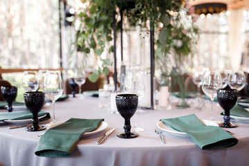 Festive wedding table setting with flowers, napkins, cutlery, glasses and candles, bright summer table decor. Wedding decor