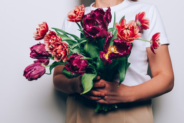 Beautiful Bunch of Peony Style Tulips in the hands of young woman, spring holiday concept, copy space, present for mothers day from kids