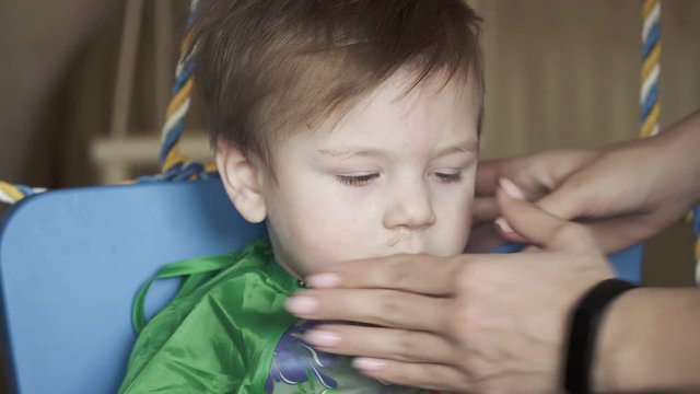 Boy wiping snot at the table