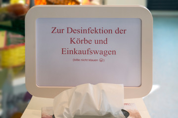 View of a sign in a supermarket. One asks to disinfect the handle of the shopping trolley and not...