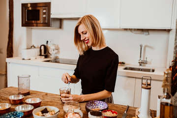 Blonde young woman cooking healthy breakfast to stay fit and be in good healht. Relaxed and carefree at home during quarantine. Lifestyle