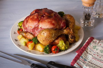 Roast chicken with breasts wrapped in bacon and vegetables
