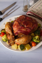 Roast chicken with breasts wrapped in bacon and vegetables