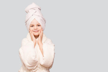 Spa skin care beauty girl wearing hair towel and white coat after beauty treatment. Beautiful child girl with perfect skin