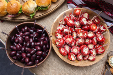 plate with olives and a plate with red hot peppers stuffed with salted cheese