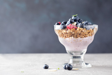 Breakfast. Cereal muesli with yogurt, blueberries, raspberries, almonds and honey on a light background. Space for text.