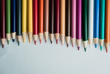 flattened colored pencils on white background