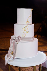 Beautiful delicious white wedding cake at the evening. Wedding cake for guests and brides