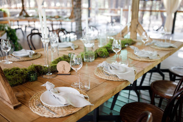 Festive wedding table setting with flowers, napkins, cutlery, glasses and candles, bright summer table decor. Wedding decor