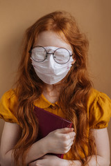 Red-haired girl in a medical mask