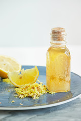 Yellow juicy Lemon, shredded Ginger and Honey on blue plate for homeopathic mixture to treat flu virus symptoms on white background