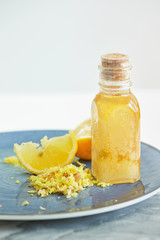 Yellow juicy Lemon, shredded Ginger and Honey on blue plate for homeopathic mixture to treat flu virus symptoms on white background