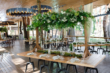 Fototapeta na wymiar Festive wedding table setting with flowers, napkins, cutlery, glasses and candles, bright summer table decor. Wedding decor