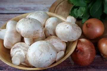 Mushrooms, spinach and onions on a wooden table