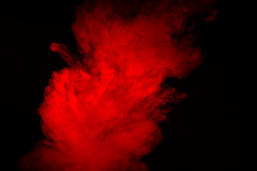 Colorful smoke close-up on a black background. Red cloud of smoke.