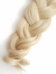 Curls of natural blonde hair on a white background.