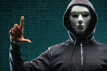Anonymous computer hacker over abstract digital background. Obscured dark face in mask and hood. Data thief, internet attack, darknet fraud, dangerous viruses and cyber security.