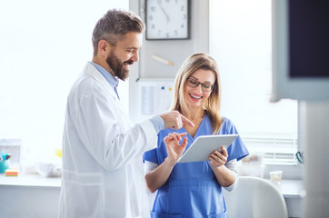 A dentist with dental assistant in modern dental surgery, working.