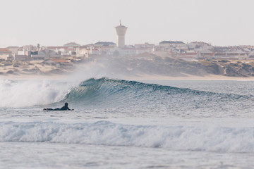 Longboarder surfing perfect small waves in Peniche 