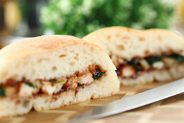 Close up sliced white bun with meat and sauce. On table lies burger cooked at home during self-isolation. Tasty quarantine menu. Burger recipe at home. Delicious american classic sandwich