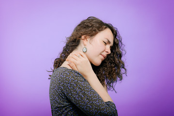 Close Up portrait stressed unhappy, young pretty woman with bad chronic neck pain, muscle sprain after long hours work, studying