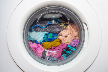 A washing machine with dirty clothes inside. Modern washing machine