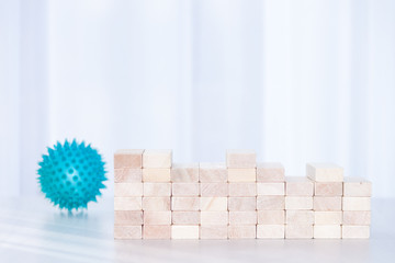 Graph from wooden blocks on white sunlight background. Coronavirus or covid-19 cases stabilization.