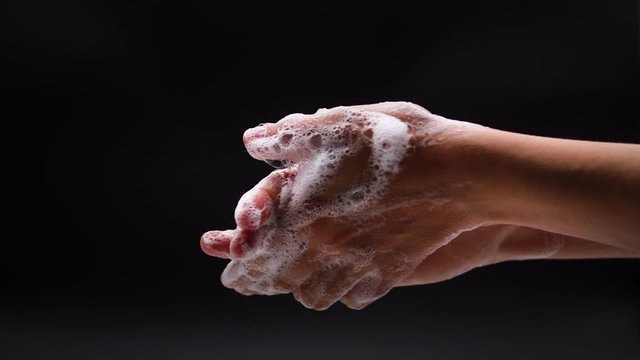 Woman washes his hands with liquid soap in a bathroom. Corona Virus idea. Extreme close up