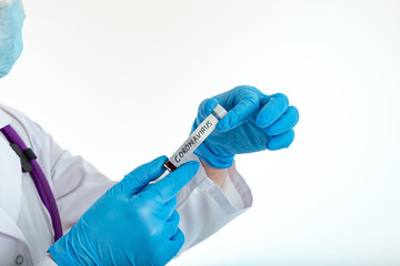 A nurse s hand in a glove holds a test tube with the inscription COVID 19, with a positive blood test for a new rapidly spreading coronavirus, close-up, shallow depth of field, selective focus.