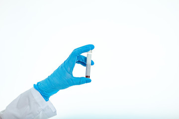 A blunted hand in a latex glove holds a blood test tube on a white background with place for text. Copy space. Female hand.