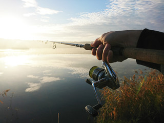 Amateur angler is fishing on autumn in the lake - obrazy, fototapety, plakaty