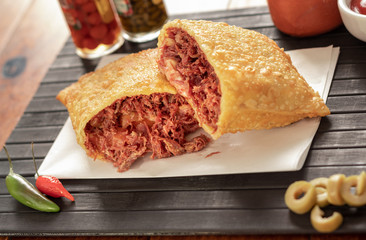 Pastel de carne seca em mesa de restaurante com pimenta e azeitona, Dry meat pastry on a restaurant...