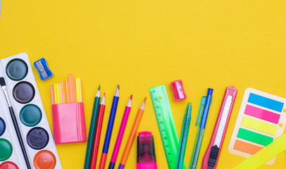 Office supplies on a yellow background. Various school supplies on a bright yellow background. Text frame with office supplies. The layout of the school. Welcome back to school. Concept of advertising