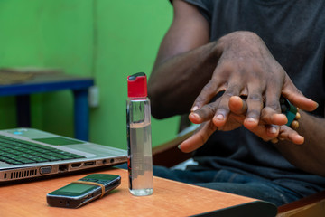 young black man using a hand sanitizer to clean hands