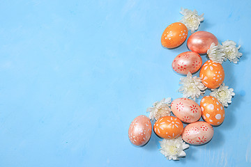 Decorated golden easter eggs on trendy blue background. Minimal holiday concept. Happy Easter...
