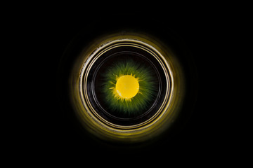Gelbe Schokolinse löst sich im Wasserglas, optisch ähnlich einem Planeten im All.