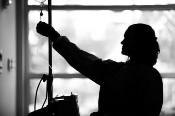 Nurse preparing IV for a patient in intensive care
