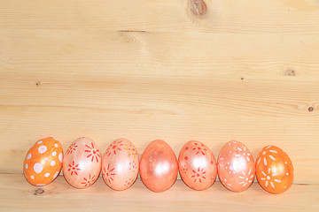 Decorated golden easter eggs on trendy wooden background. Minimal holiday concept. Happy Easter background, place for text, postcard, banner for the screen.