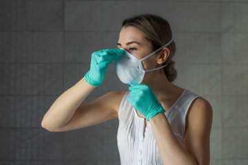 young woman in medical mask. portrait of a young woman in a protective mask and gloves against...