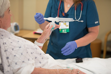 Respiratory therapist working with patient after having trouble breathing due to illness