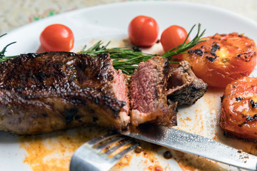 roast beef fillet steak meat with rosemary on a white plate. Juicy piece of meat. Delicious dinner.