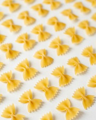 Obraz premium Pasta, durum wheat pasta in the form of bows, food pattern, top view, copy space flat lay